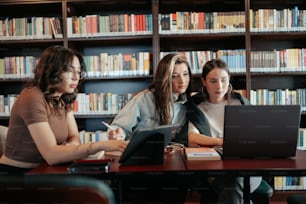 Un gruppo di donne sedute a un tavolo davanti a un computer portatile