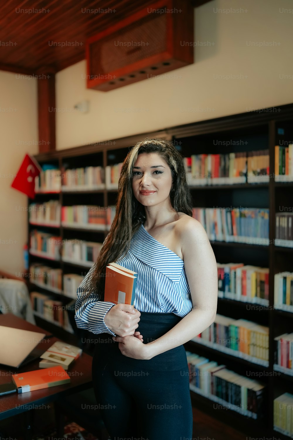 Una donna che tiene un libro in una biblioteca