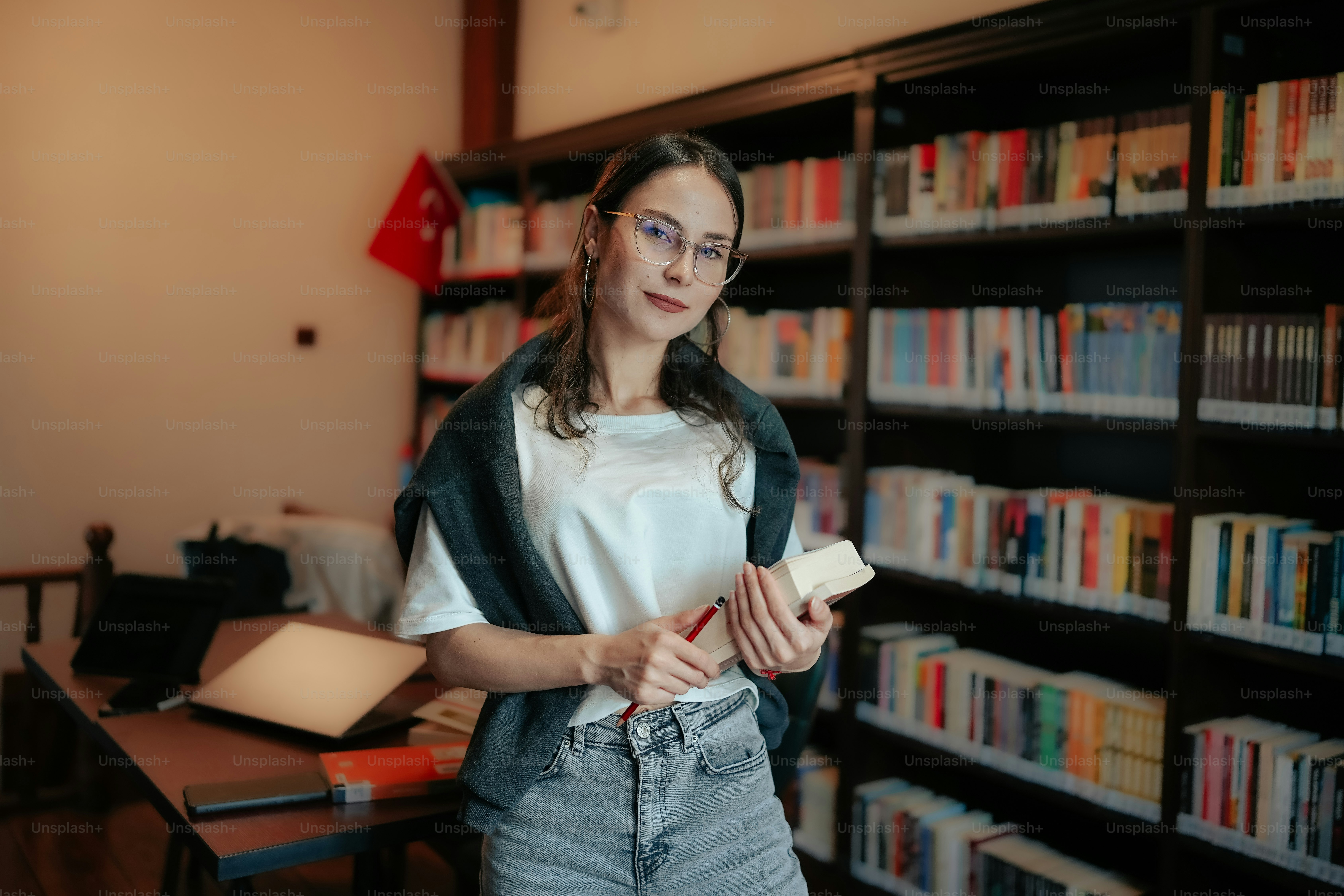 A woman standing in front of a book shelf photo – Books Image on Unsplash