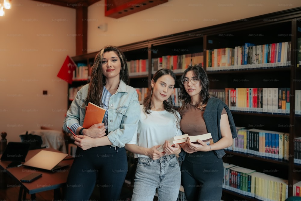 um grupo de mulheres de pé um ao lado do outro em uma biblioteca