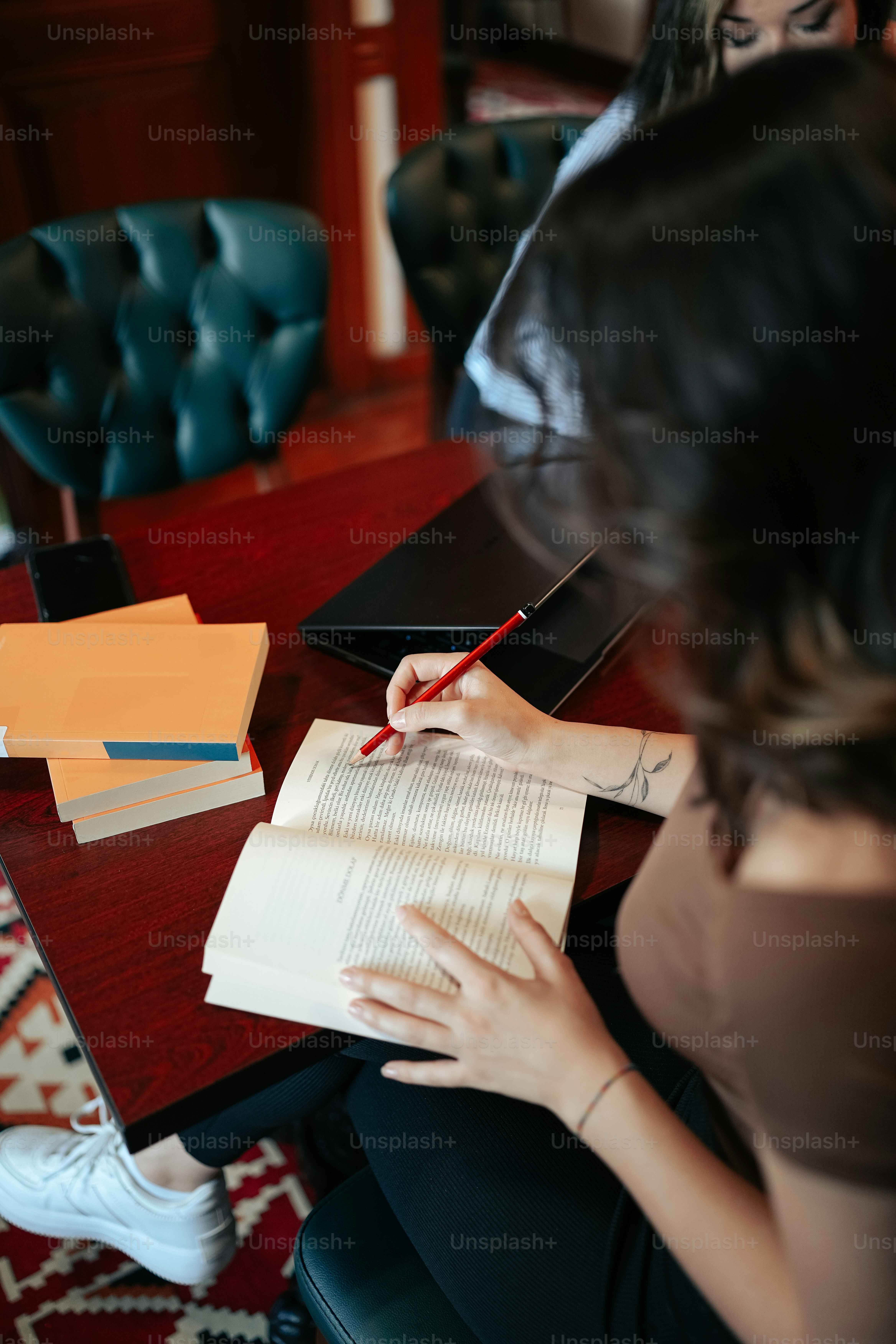 une femme assise à une table avec un cahier et un stylo