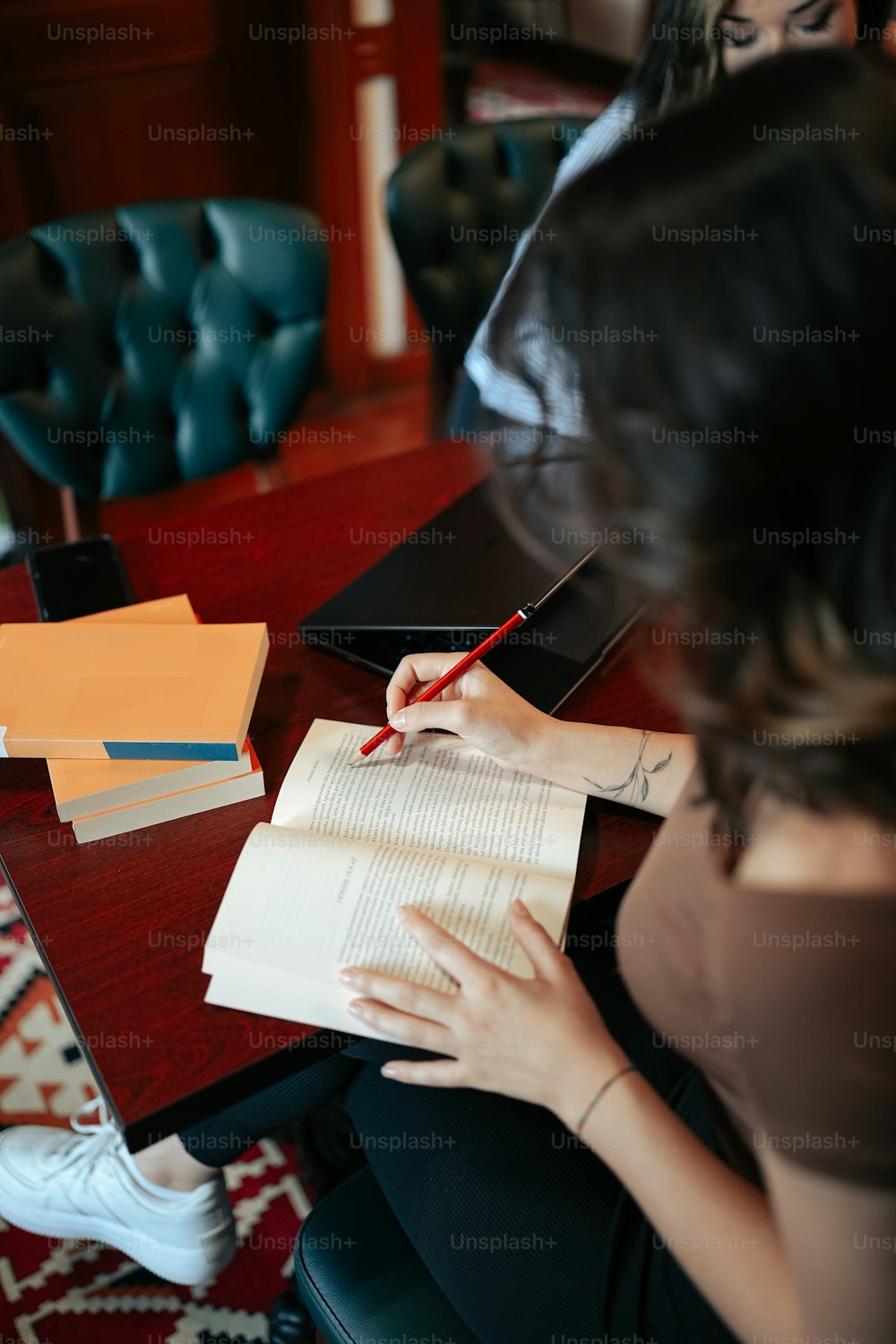 a woman sitting at a table with a notebook and pen