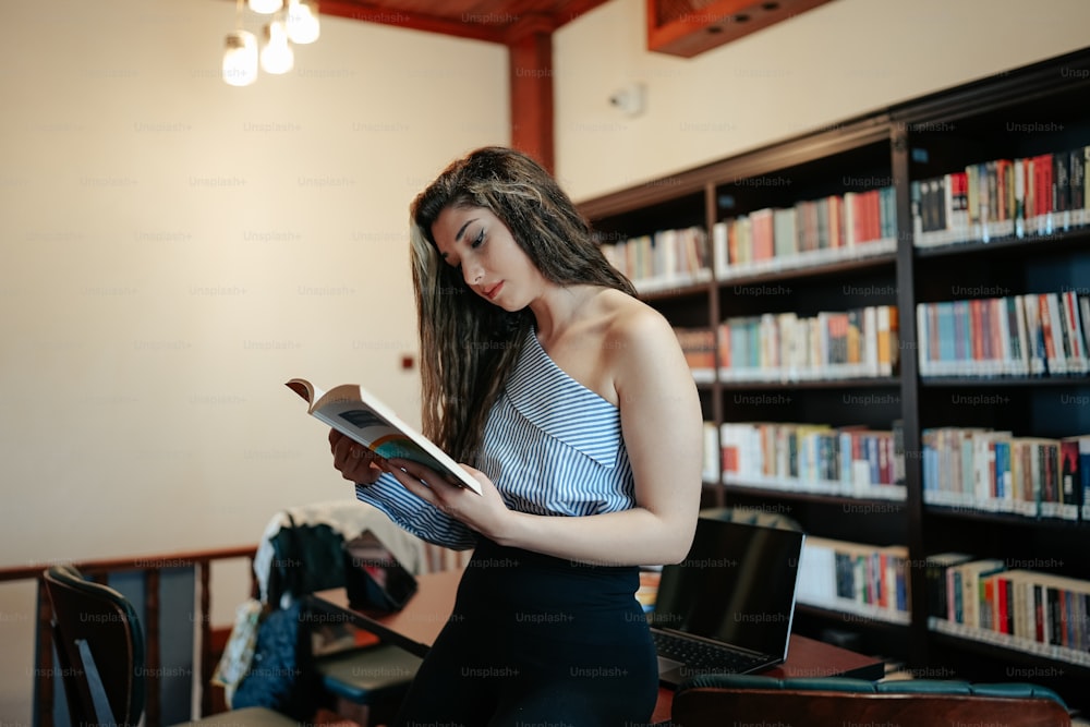 a woman reading a book in a library