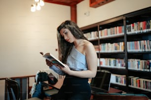 uma mulher lendo um livro em uma biblioteca