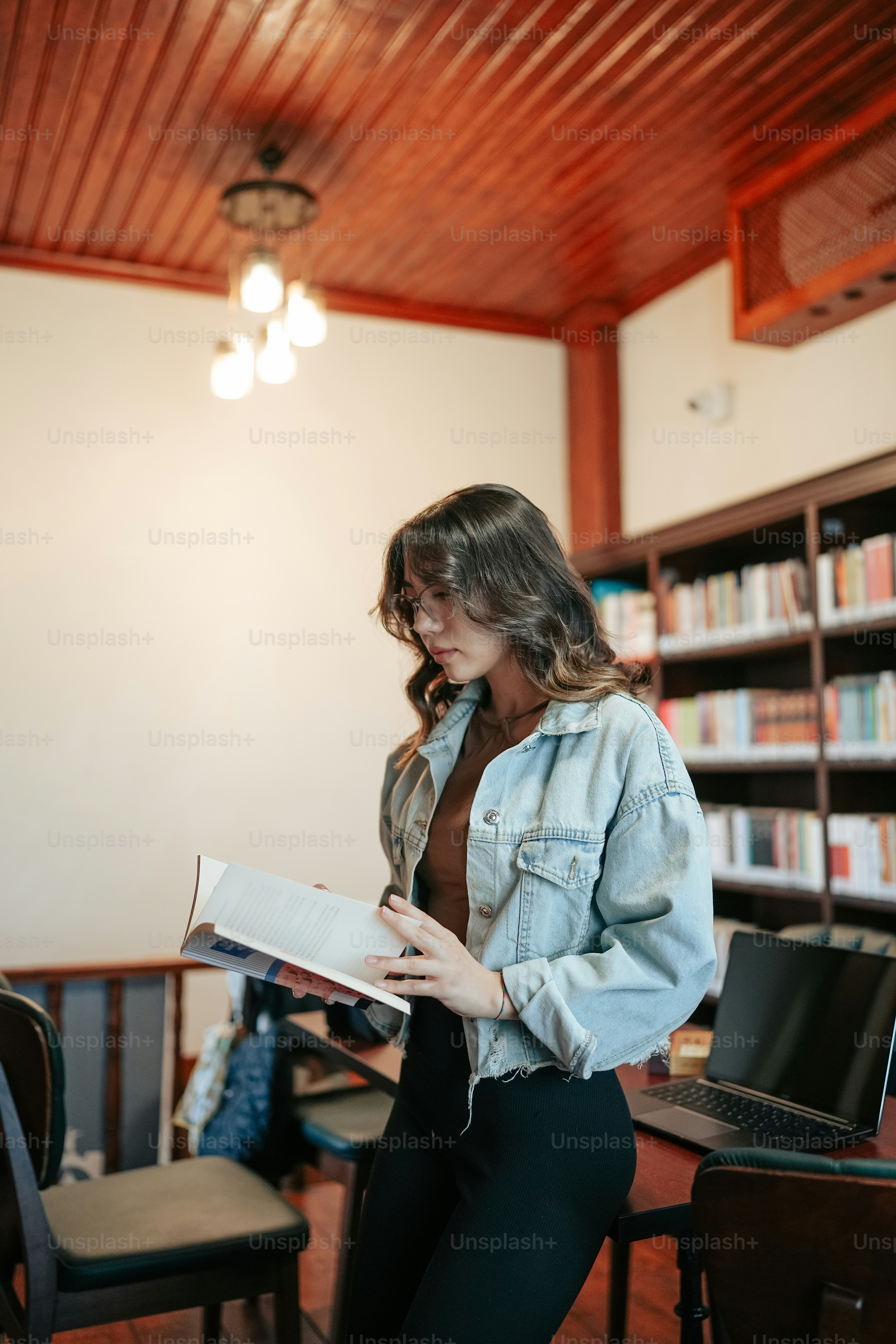 a woman sitting on a chair reading a book