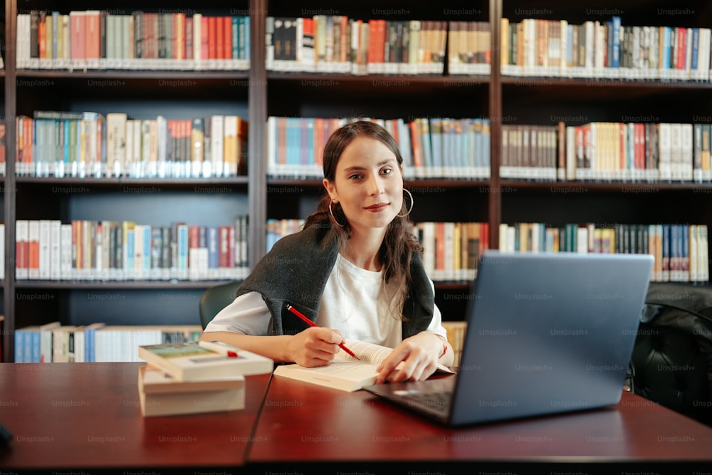 a woman sitting at a desk in front of a laptop computer