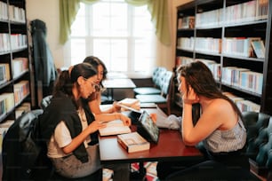 two women sitting at a table in a library