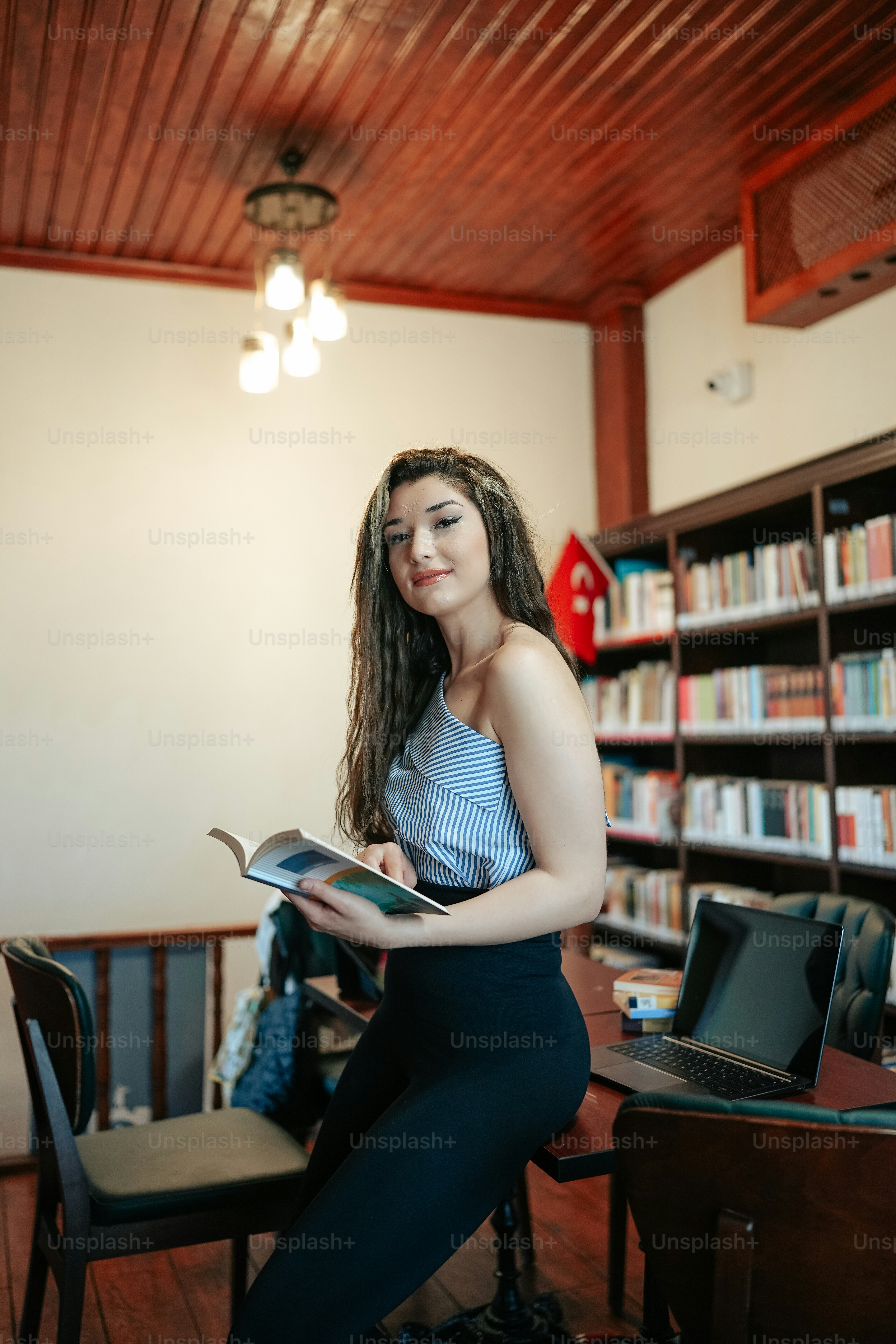 a woman sitting on a chair reading a book