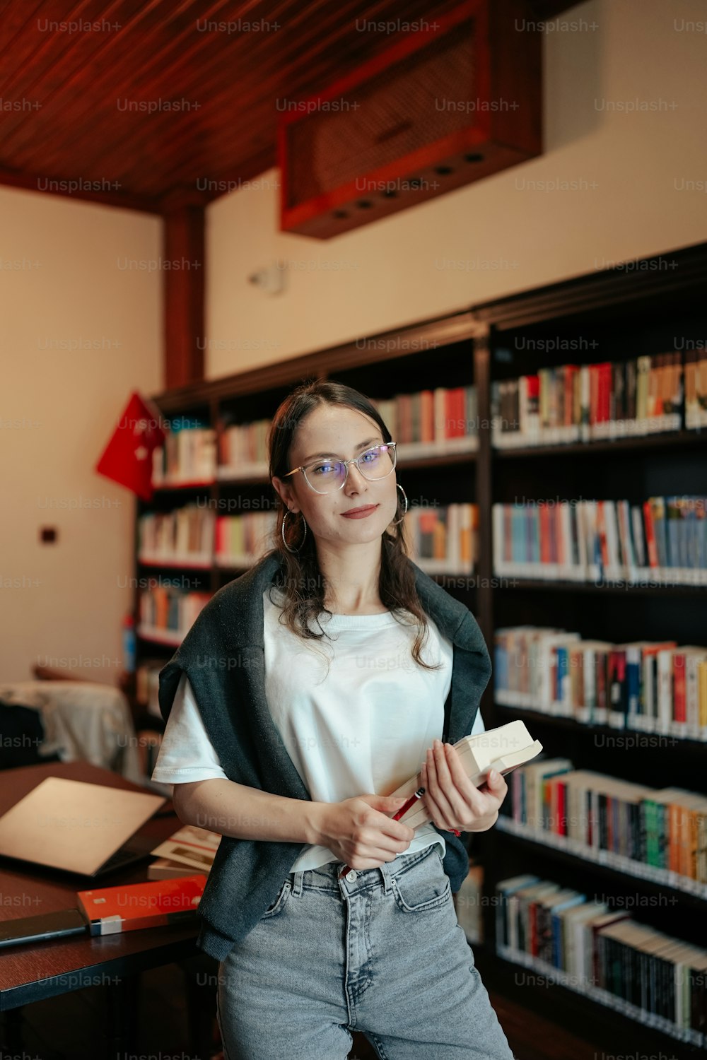 Una mujer parada frente a un estante de libros
