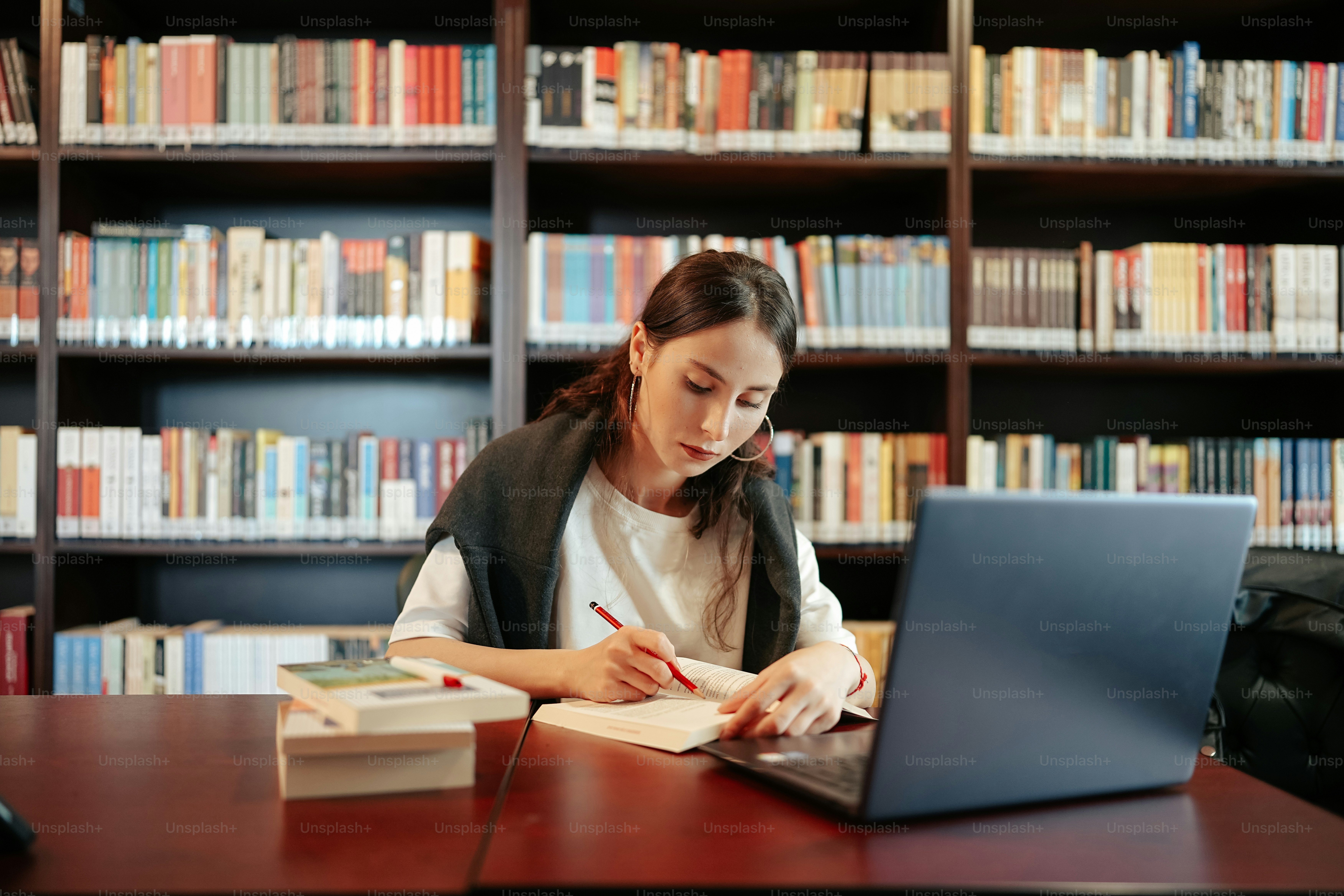 a woman sitting at a table in front of a laptop computer