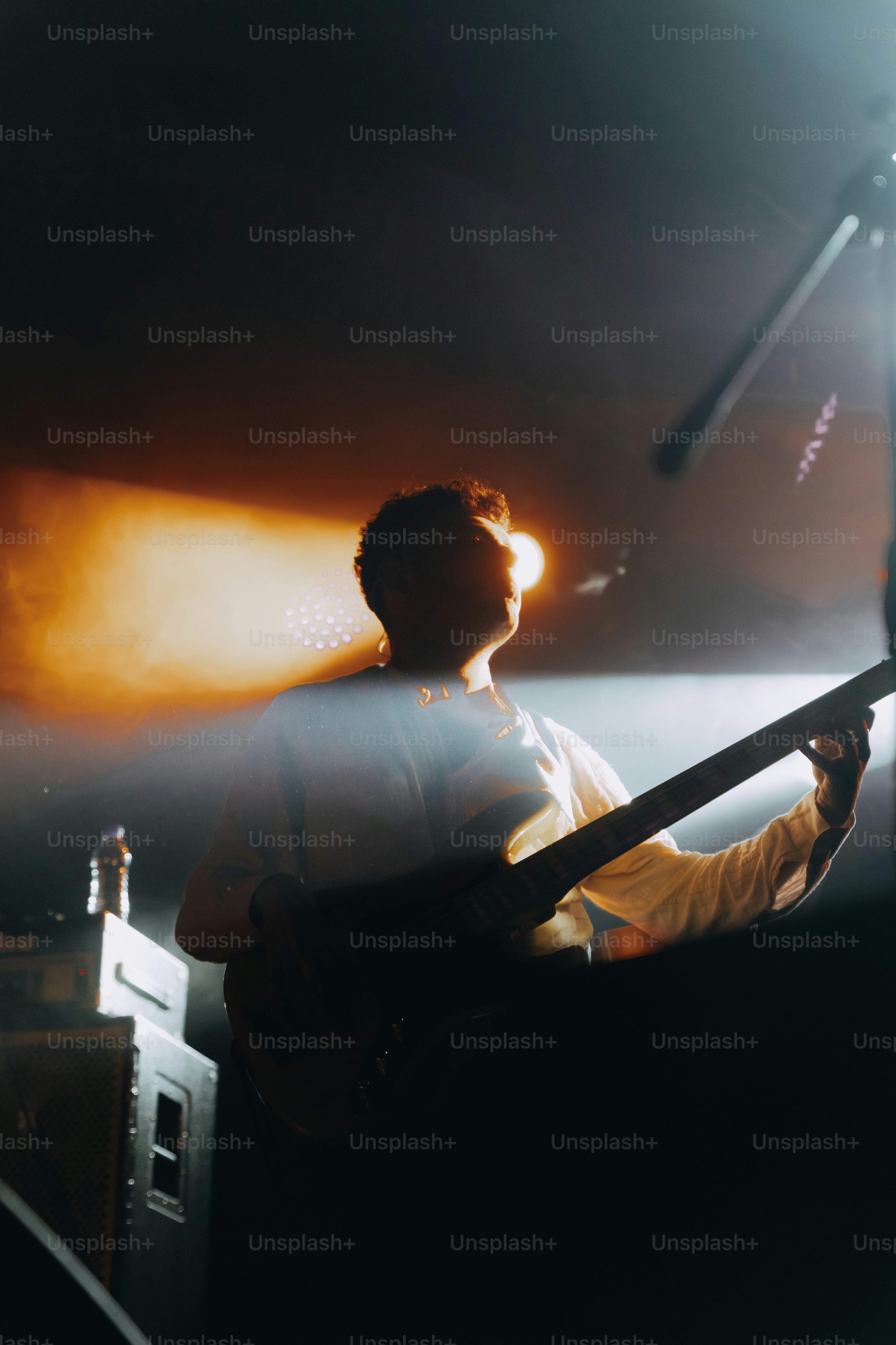 a man holding a guitar in front of a microphone