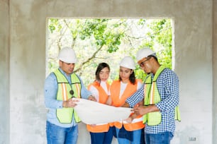 a group of construction workers looking at a blueprint