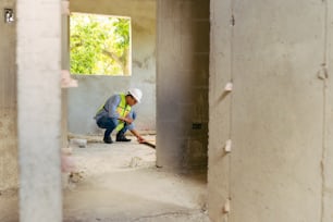 a man kneeling down in a room under construction