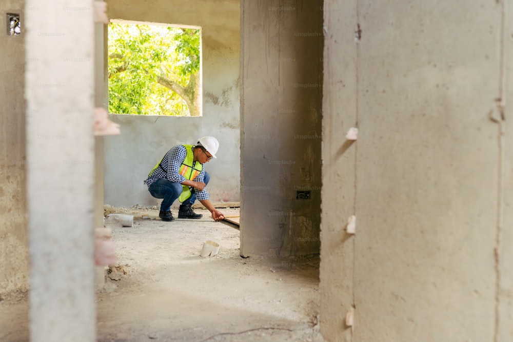 a man kneeling down in a room under construction