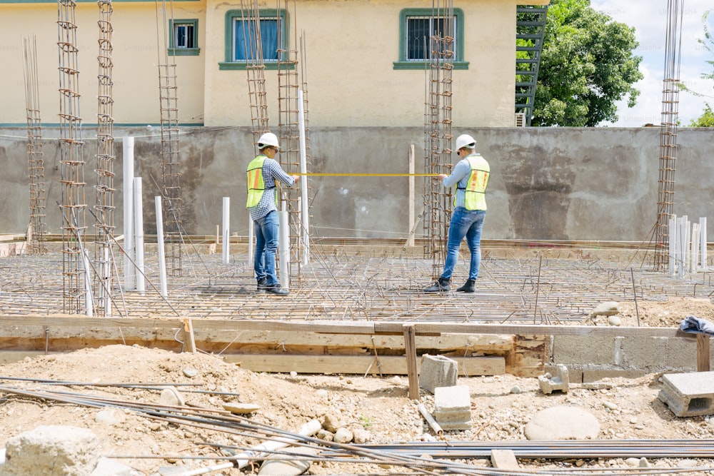 dois trabalhadores da construção civil em pé em um canteiro de obras