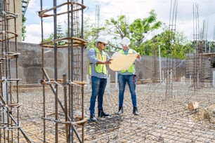 a couple of men standing next to each other on a construction site