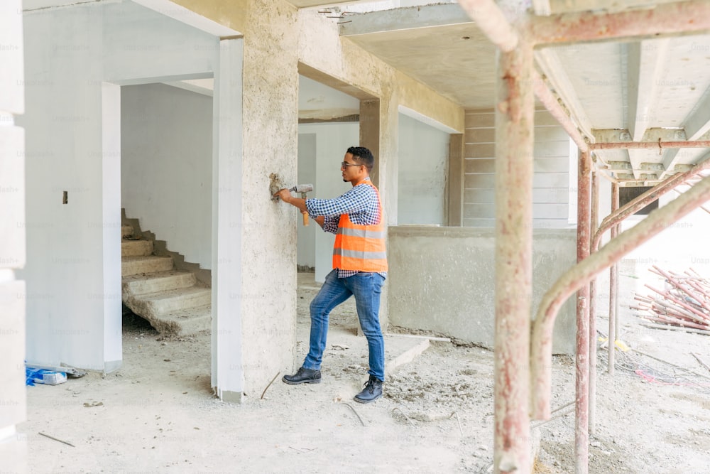 a man in an orange and blue striped shirt is holding a hammer