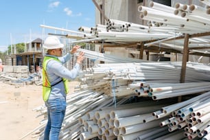 a man standing next to a pile of pipes