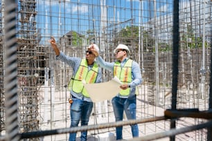 a couple of men standing next to each other on a construction site