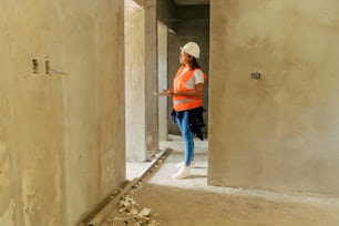 a woman in an orange vest standing in a doorway