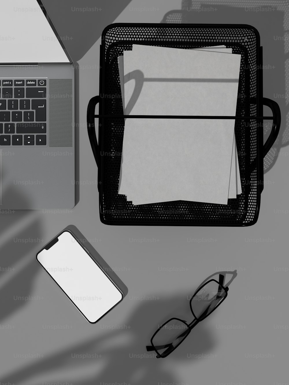 ein Laptop, der auf einem Schreibtisch neben einer Brille sitzt