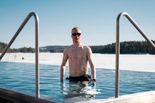 a man standing in a swimming pool with no shirt on