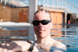 a man wearing sunglasses in a swimming pool