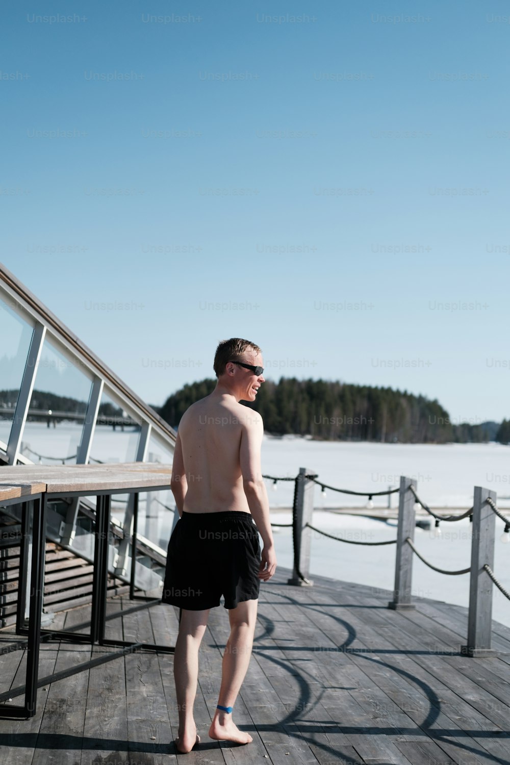 a man standing on a pier next to a body of water