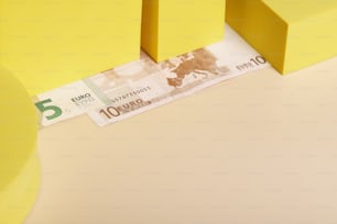 a five euro bill is laying on a yellow surface