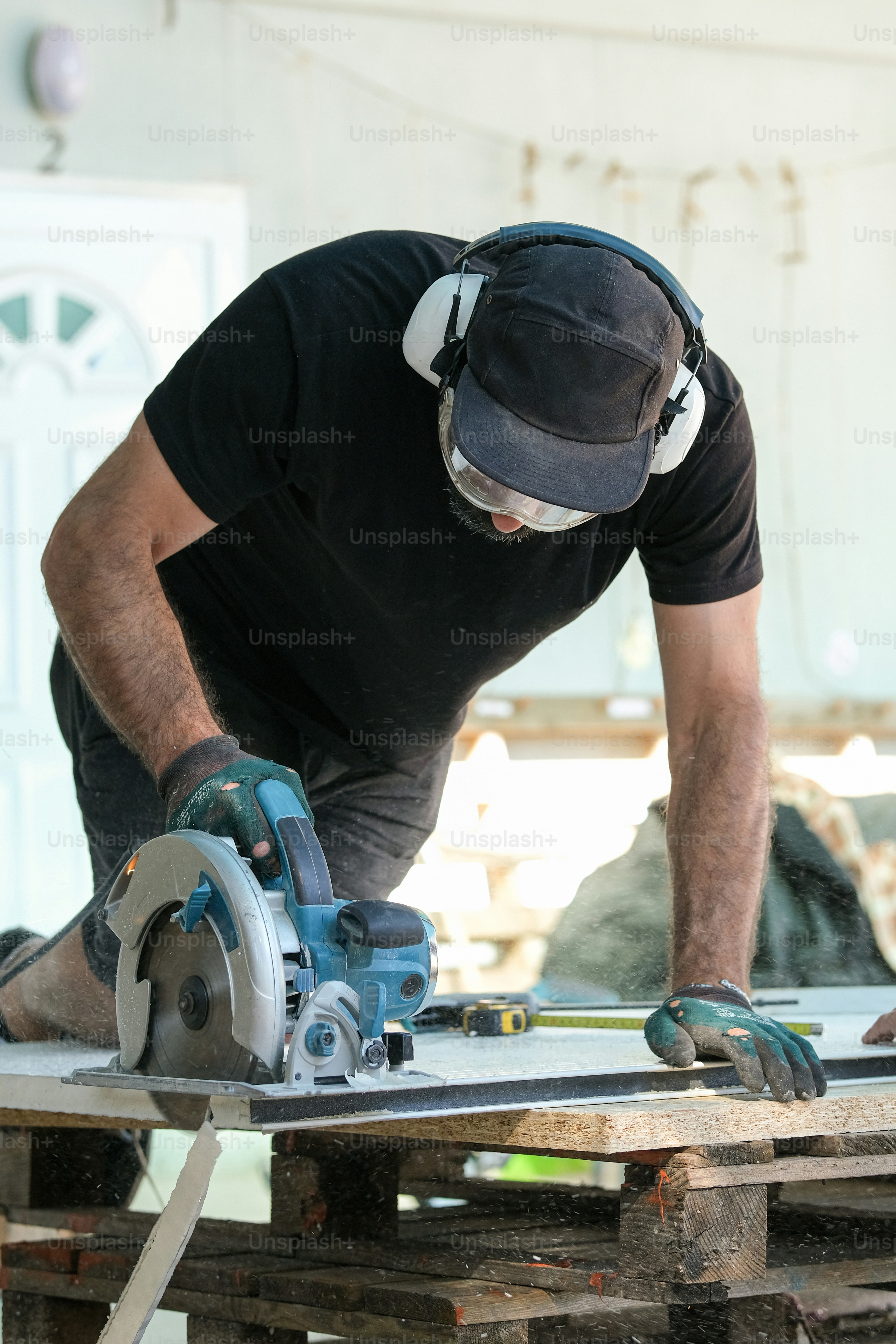 um homem usando uma serra circular para cortar um pedaço de madeira