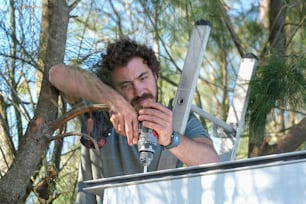 a man with a beard is holding a drill