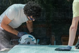 a man sanding a table with a circular saw