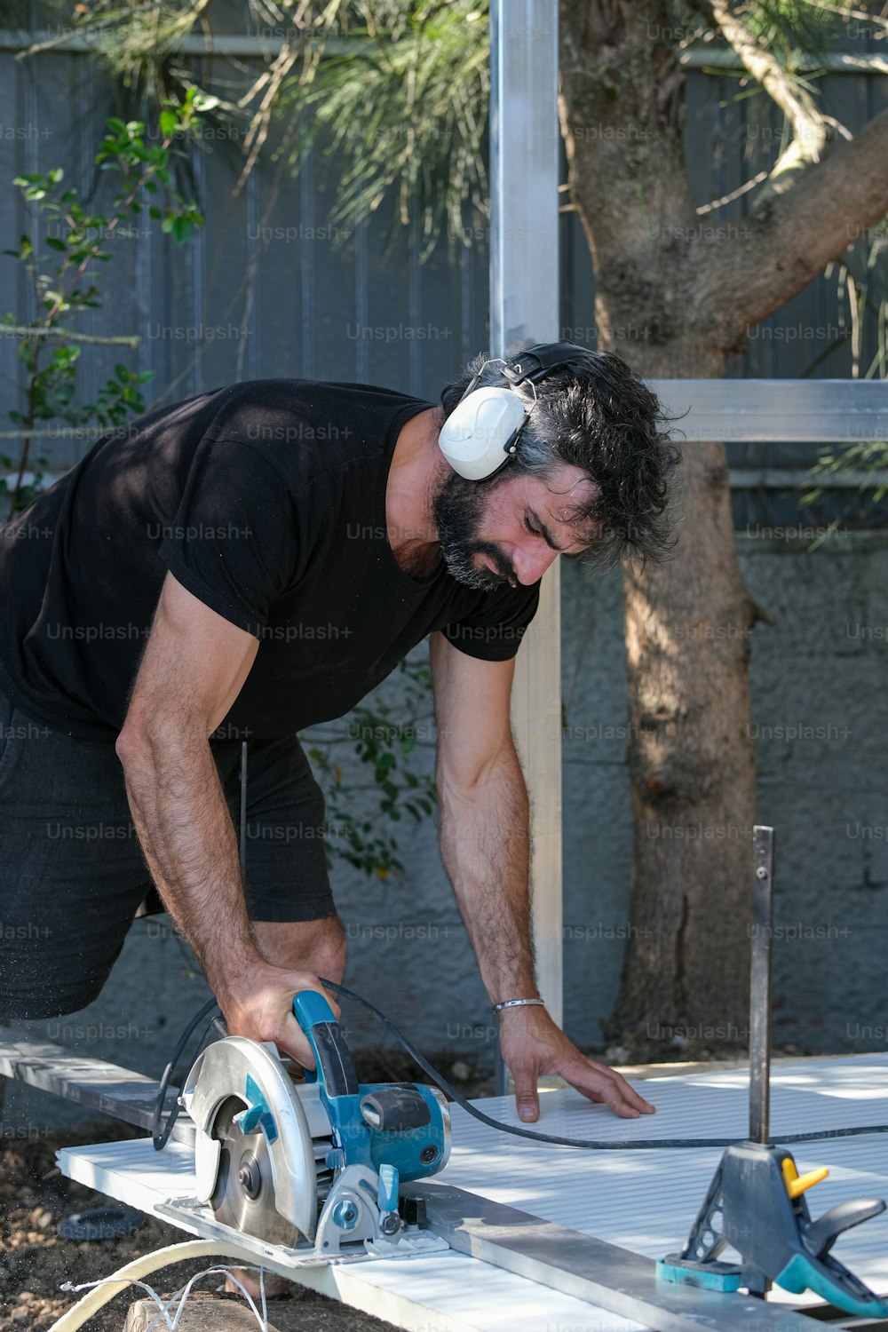 a man using a circular saw to cut a piece of wood