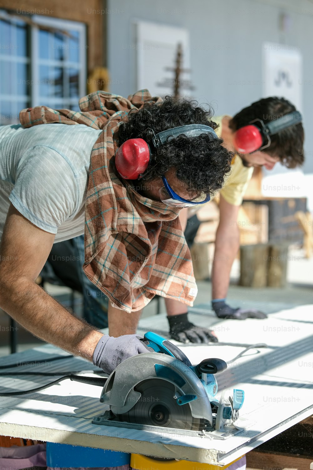 a man wearing goggles while working on a piece of wood
