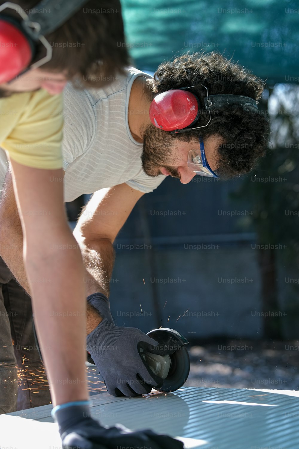 a man in safety goggles working on a piece of metal