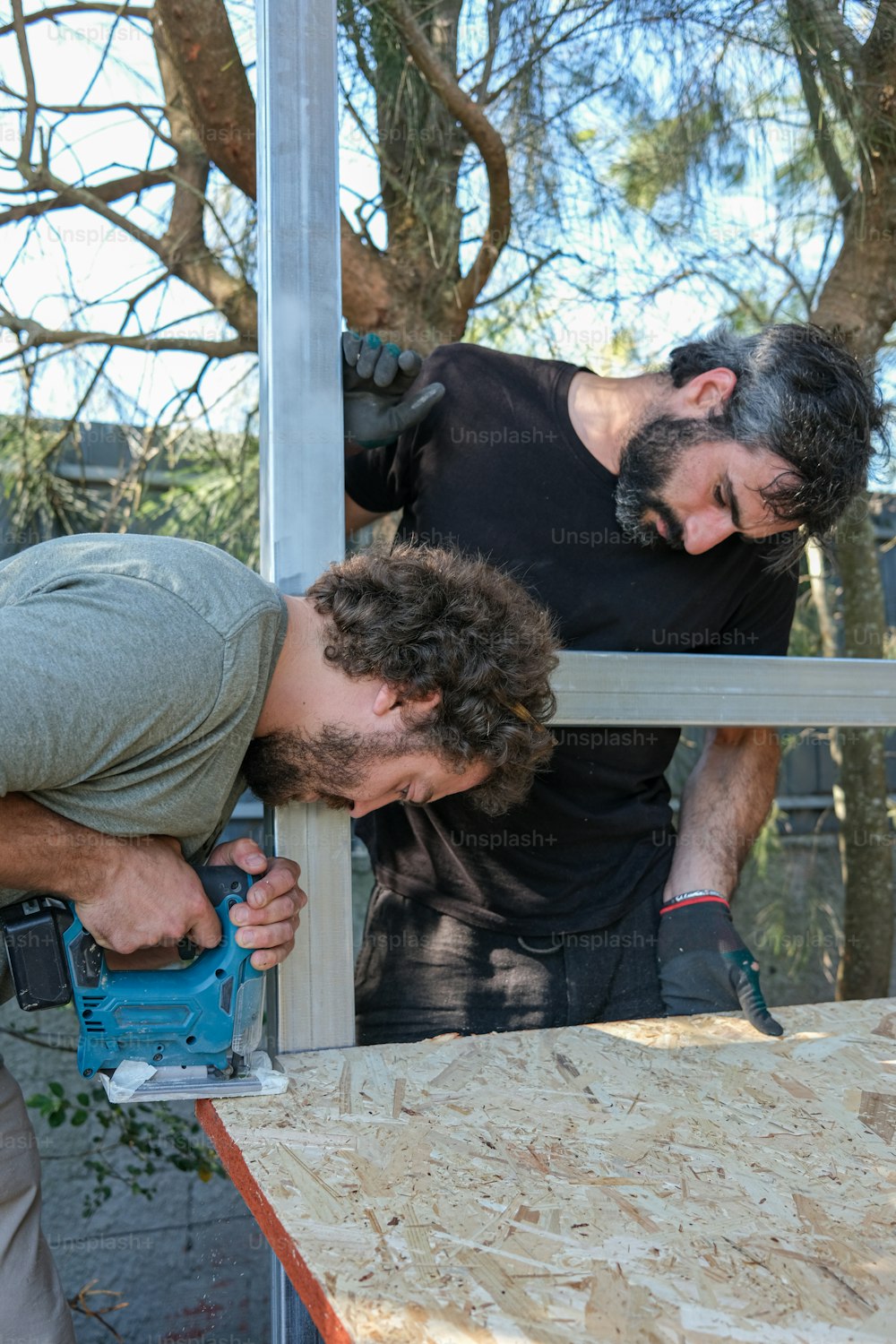 Zwei Männer, die an einem Stück Holz arbeiten