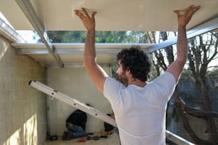 a man is holding up a white awning