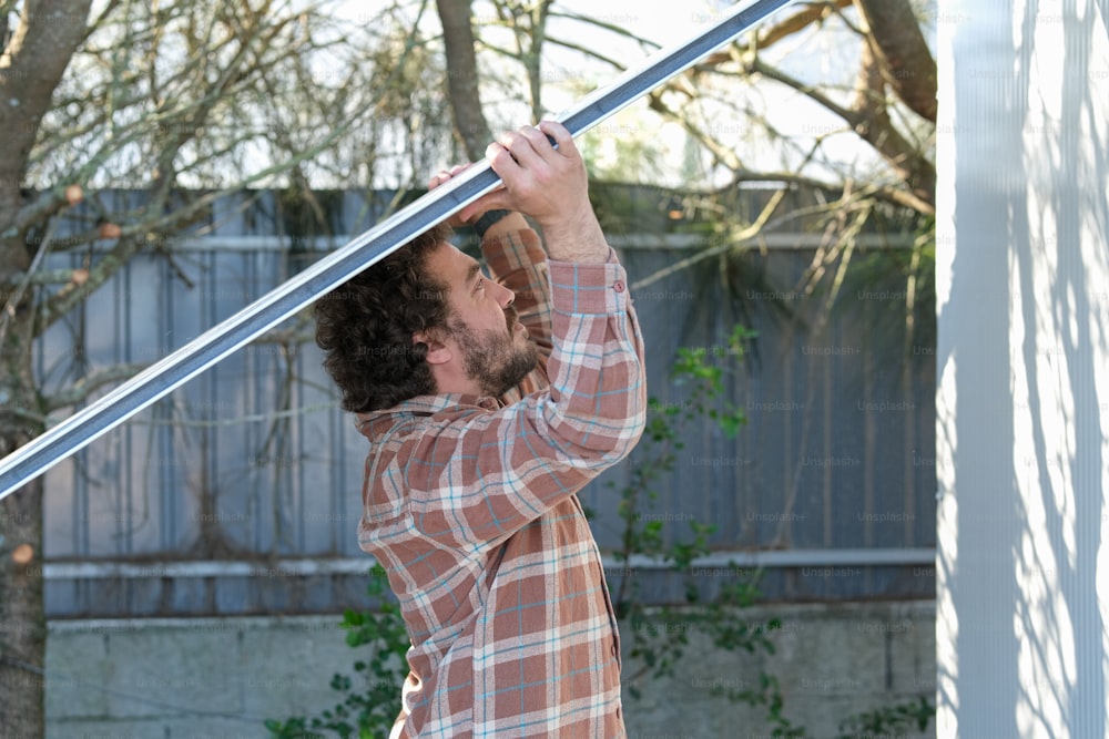 a man holding onto a pole in a backyard