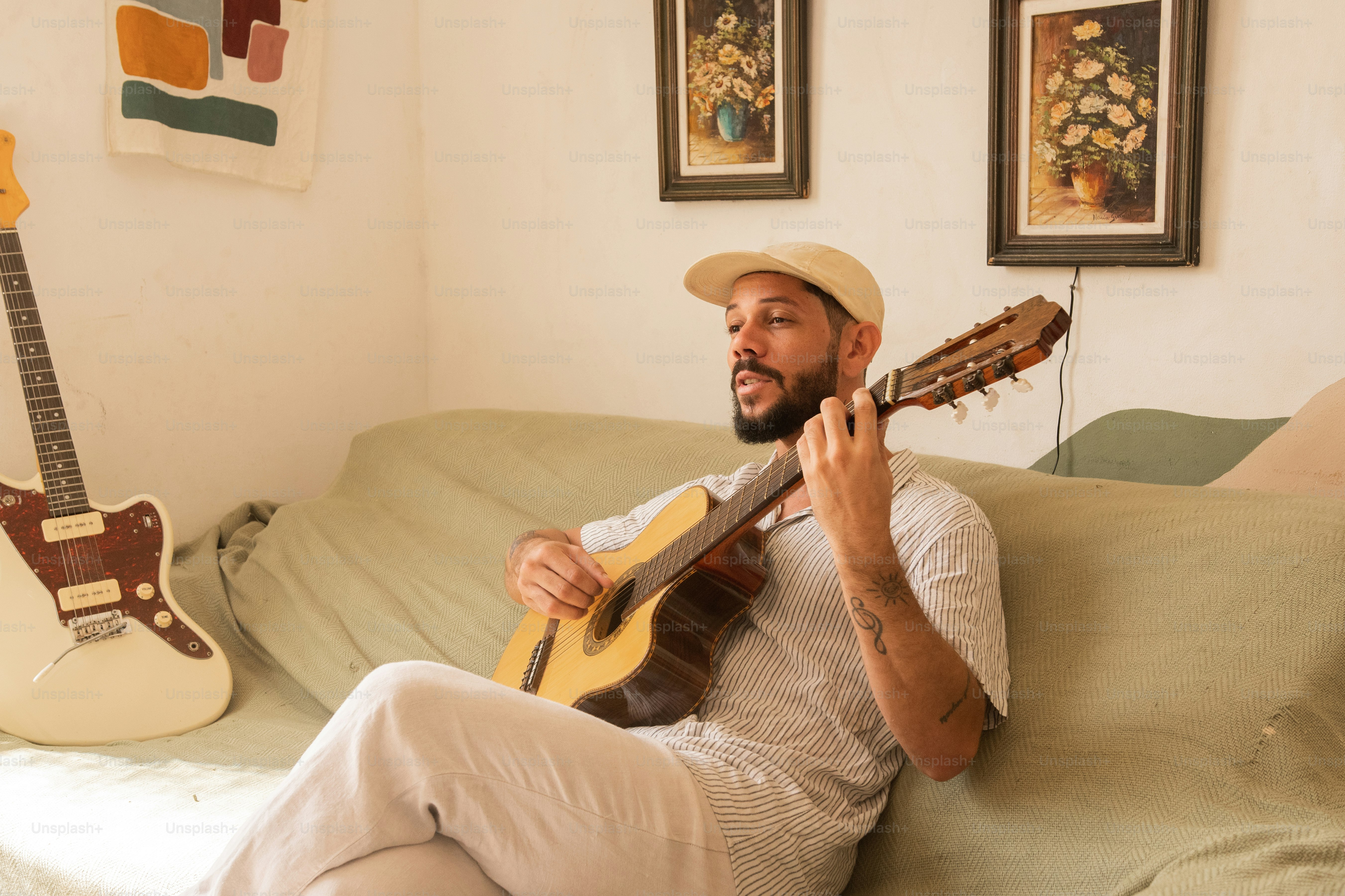 a man sitting on a couch playing a guitar