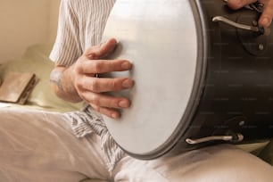 a man is holding a large drum in his hand
