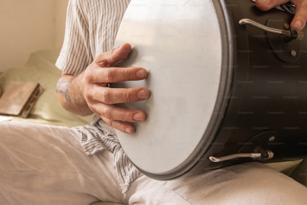 a man is holding a large drum in his hand