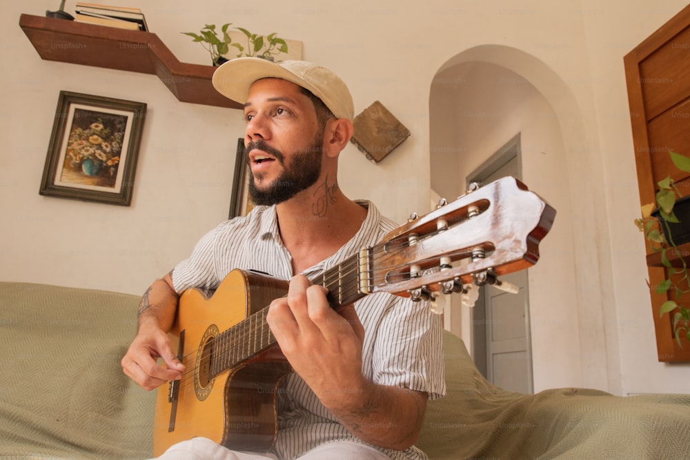 a man sitting on a couch playing a guitar