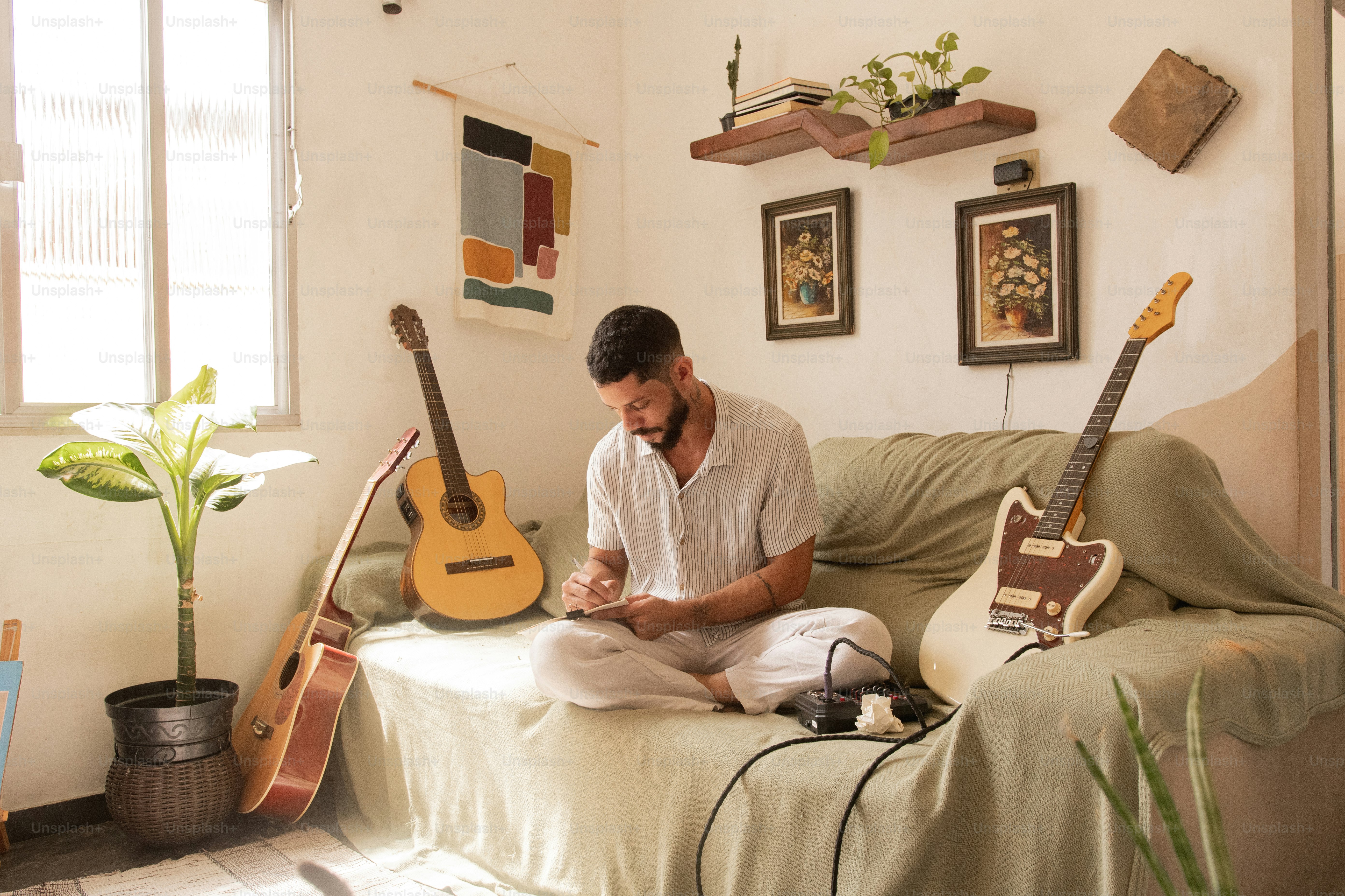 a man sitting on a couch with a guitar