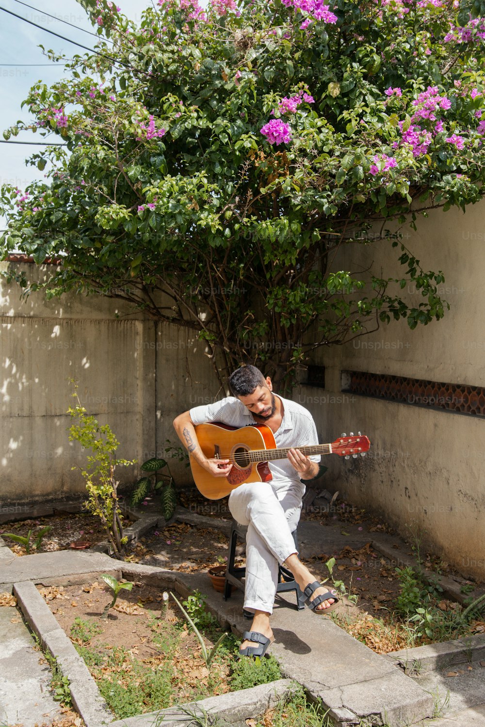 Un hombre sentado en una silla tocando una guitarra