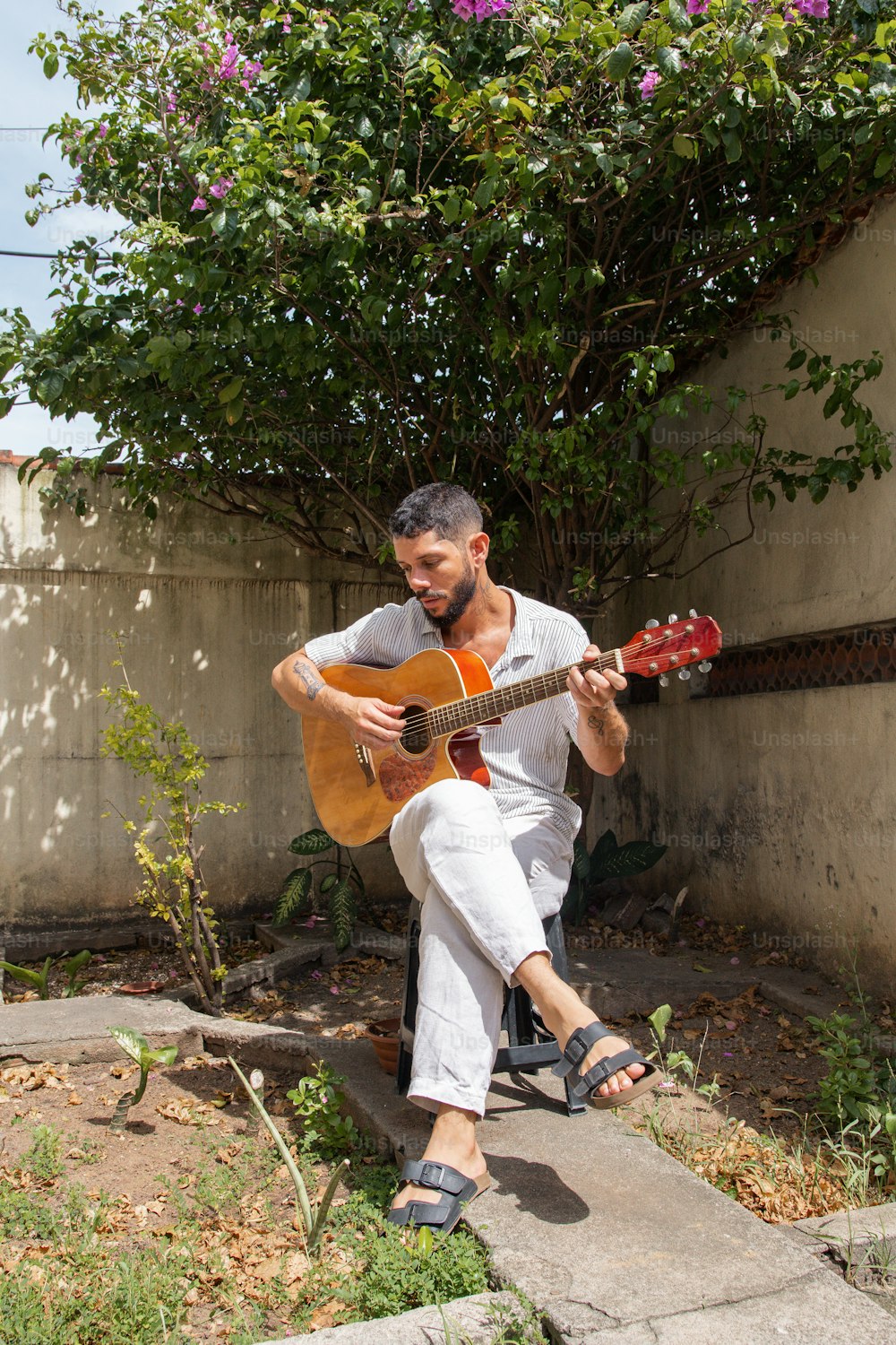 Un hombre sentado en los escalones tocando una guitarra