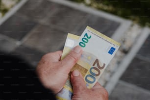 a person holding a bank note in their hand