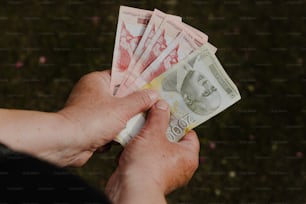 eine Person, die einen Haufen Geld in der Hand hält