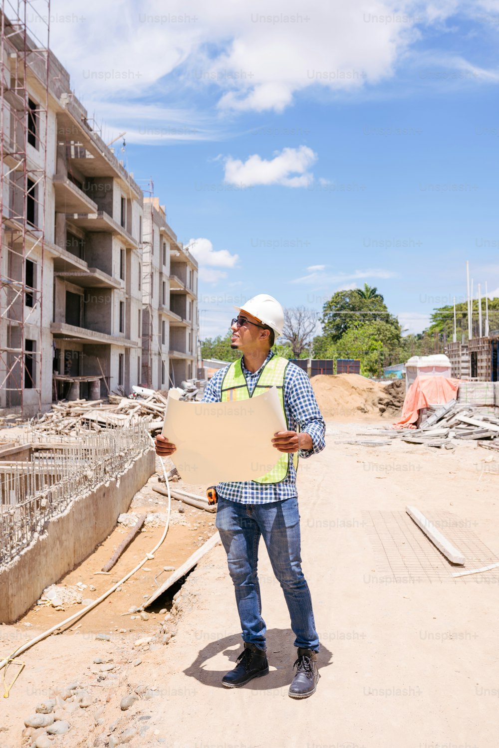 Ein Bauarbeiter, der ein Schild vor einem Gebäude hält