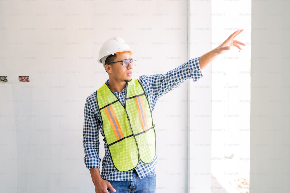 a man wearing a safety vest pointing at something