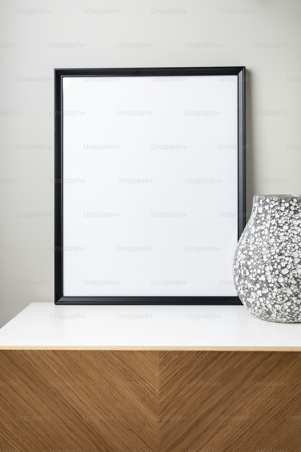 um vaso branco sentado em cima de uma cômoda de madeira